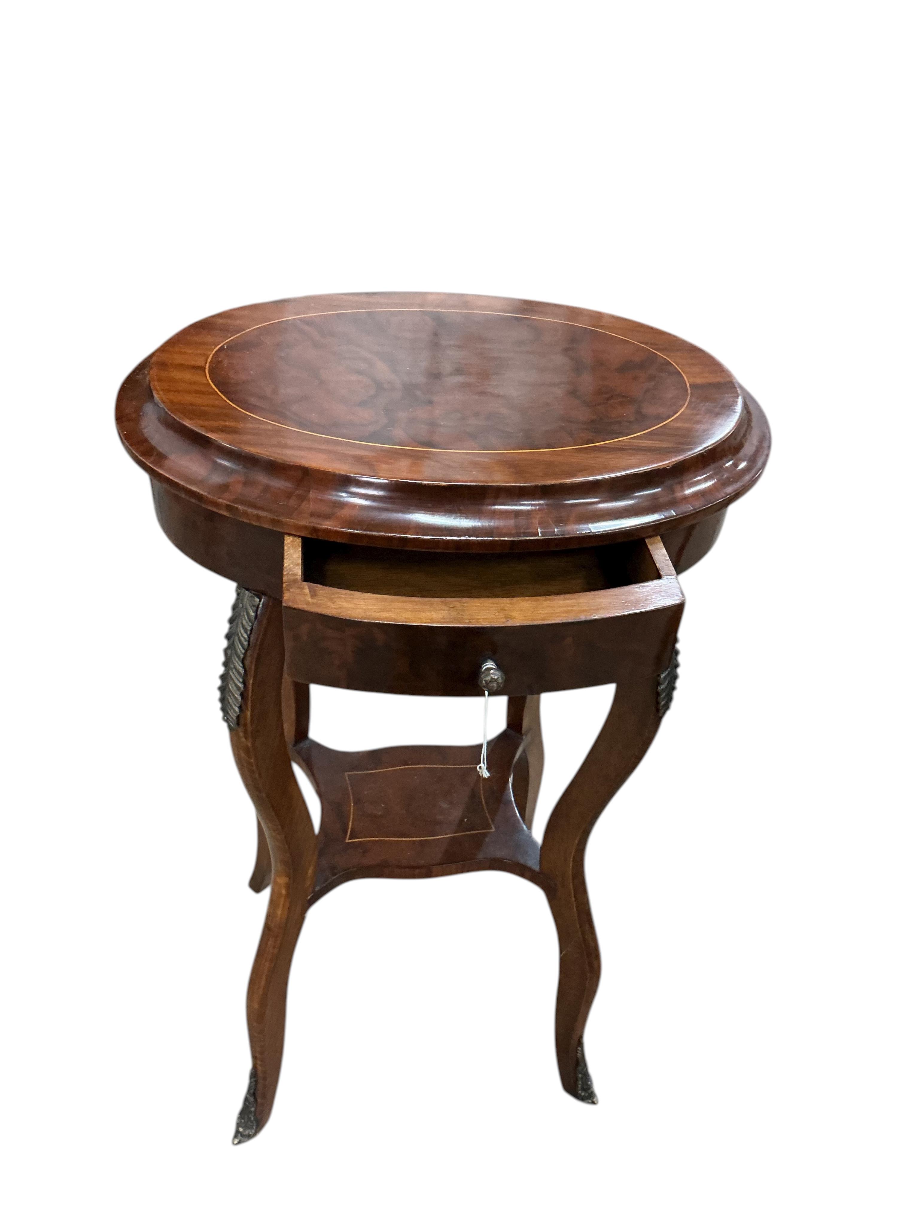 A pair of Louis XVI style oval gilt metal mounted walnut two tier occasional tables, width 45cm, depth 33cm, height 76cm